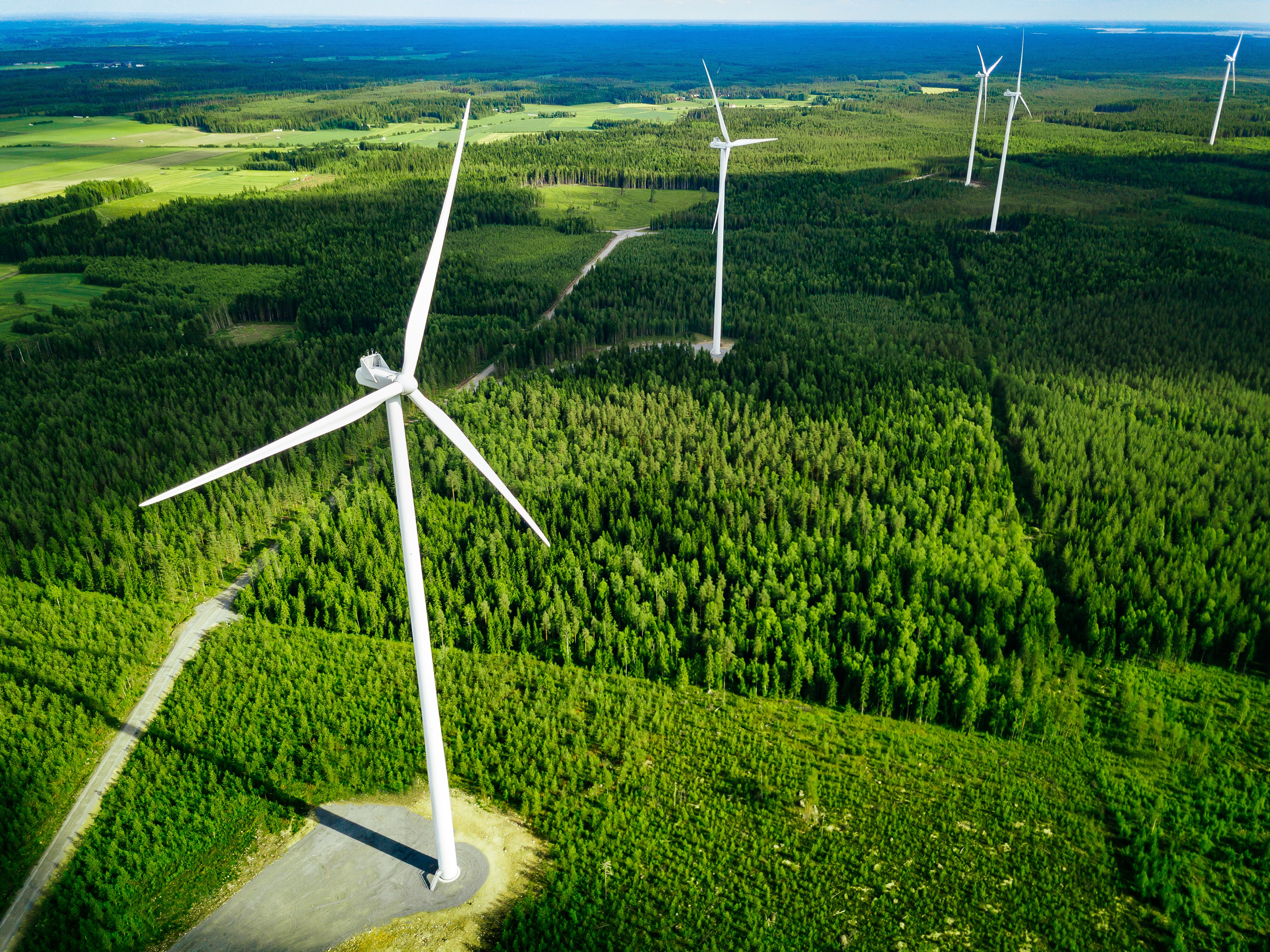 Реализовывать энергию. Ветряные электростанции. Ветровая электростанция. Ветряные электростанции в Финляндии. Ветрогенератор в лесу.